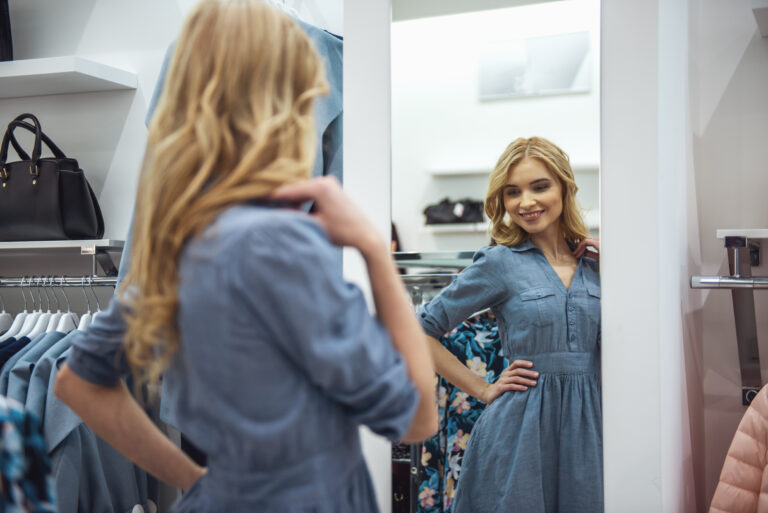 Women standing in front of the mirror trying on clothes